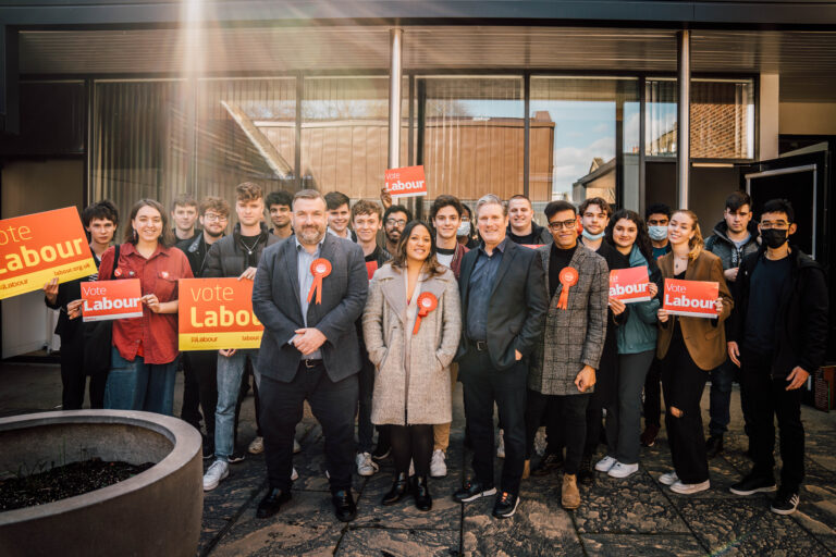 Keir Starmer with a large group of student, many holding signs reading 'Vote Labour'