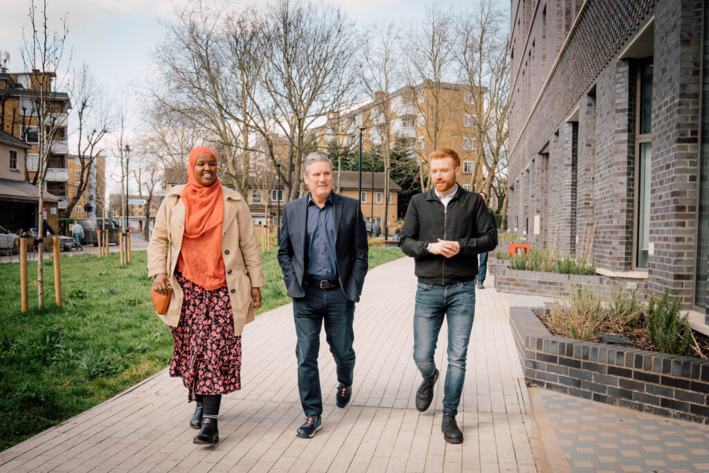 Keir Starmer walking with two people through a housing estate