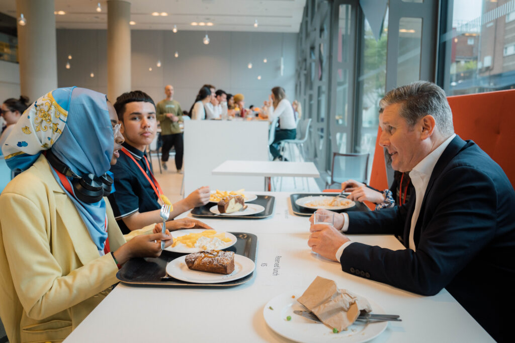 Keir Starmer sitting at a table with two Camden Youth MPs