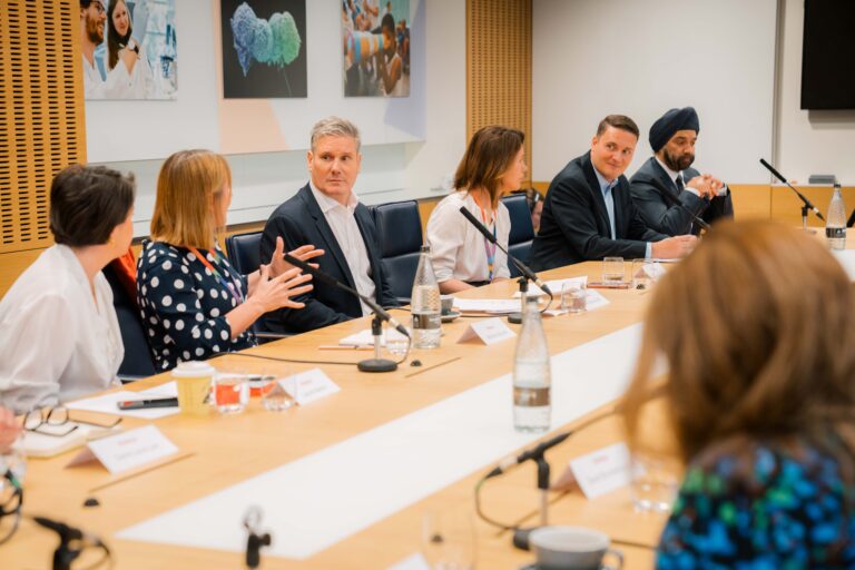Keir Starmer sitting at a boardroom with six other people in view