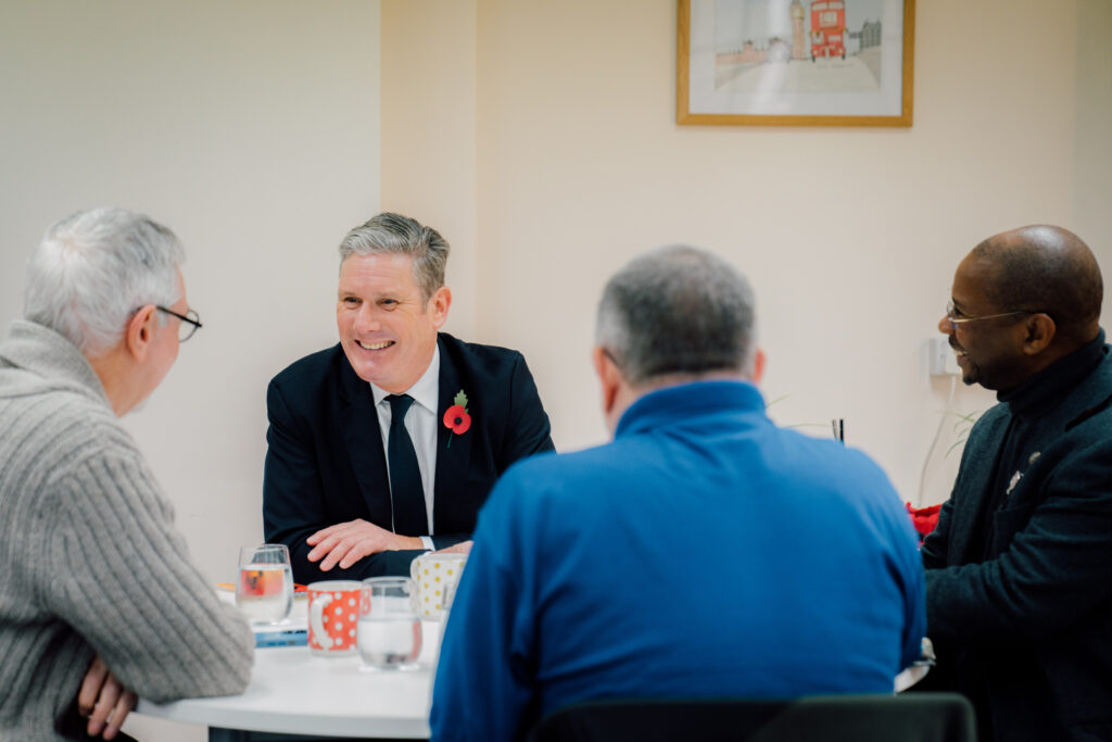 Keir Starmer sitting at a table talking to three armed forces veterans